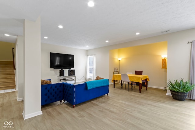 living room with visible vents, stairway, wood finished floors, and recessed lighting