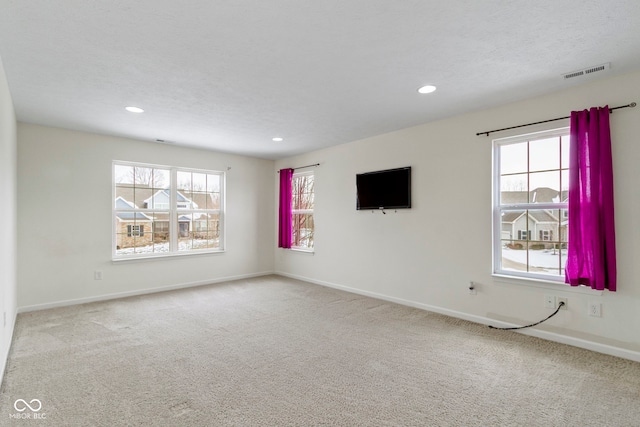 spare room with carpet, visible vents, baseboards, and recessed lighting