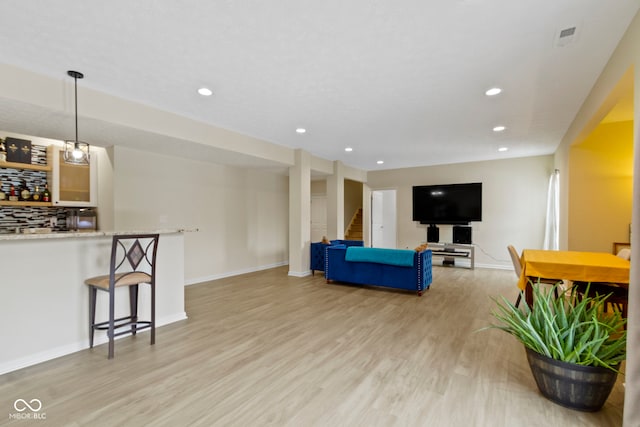 living room with light wood-style floors, baseboards, stairway, and recessed lighting