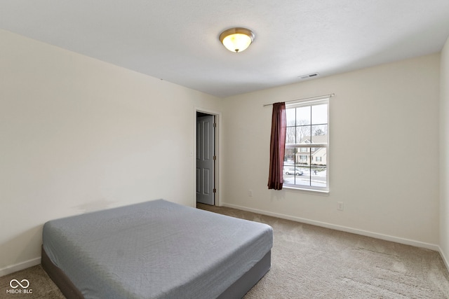 carpeted bedroom featuring visible vents and baseboards