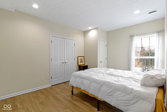 bedroom featuring recessed lighting, a closet, visible vents, wood finished floors, and baseboards