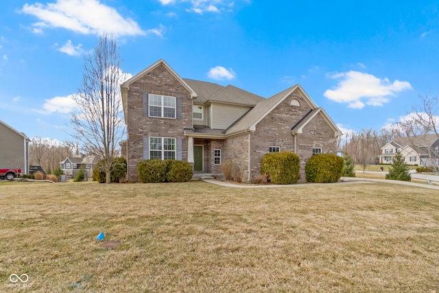 traditional home featuring roof with shingles, a front lawn, and brick siding