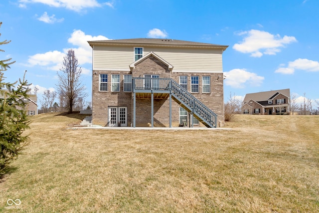 rear view of property featuring stairs, a yard, brick siding, and a wooden deck