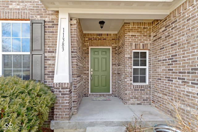 doorway to property featuring brick siding