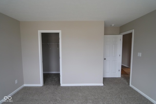 unfurnished bedroom with a walk in closet, carpet floors, and a closet