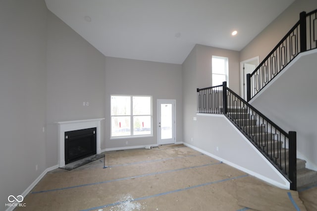 unfurnished living room with a towering ceiling