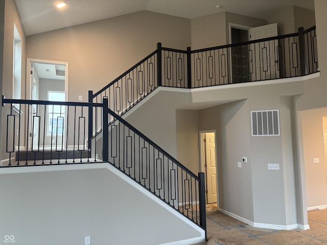 staircase featuring high vaulted ceiling