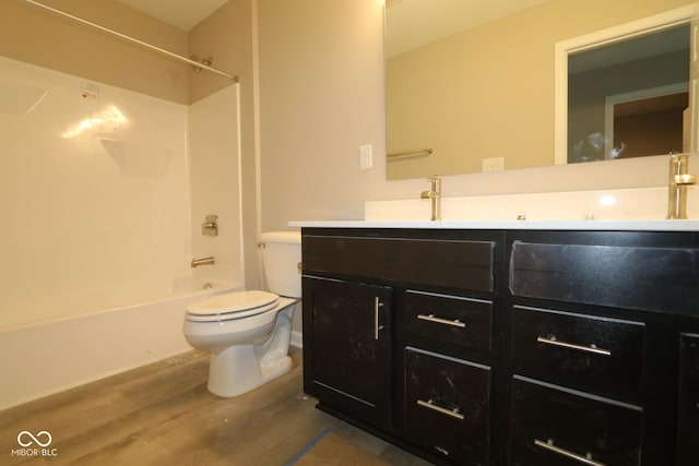 full bathroom with wood-type flooring, vanity, washtub / shower combination, and toilet