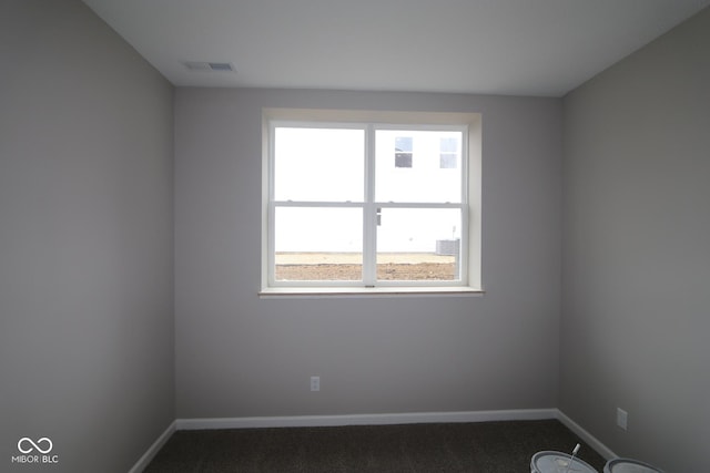 spare room with dark colored carpet