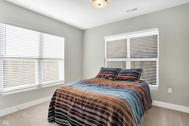 bedroom with multiple windows and carpet