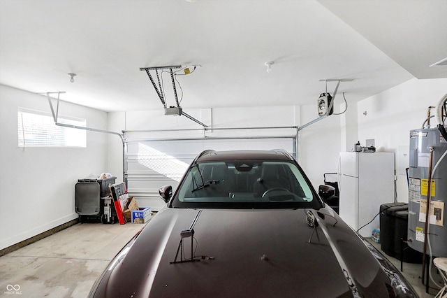 garage with a garage door opener, water heater, and white fridge