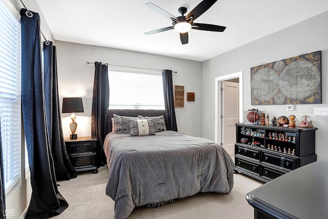 carpeted bedroom with ceiling fan and multiple windows