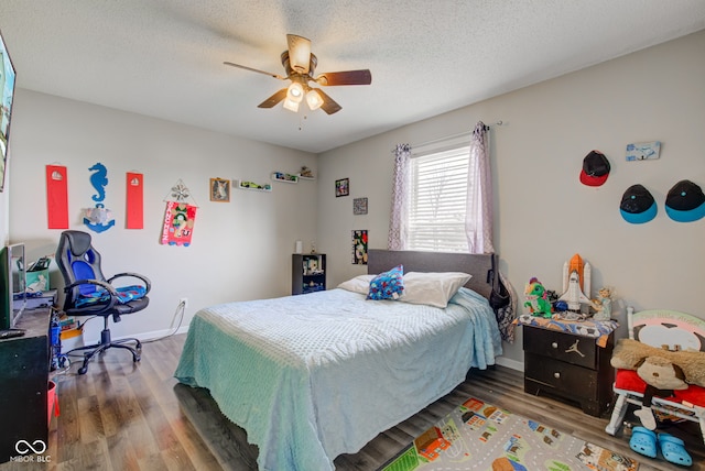 bedroom featuring ceiling fan, hardwood / wood-style floors, and a textured ceiling