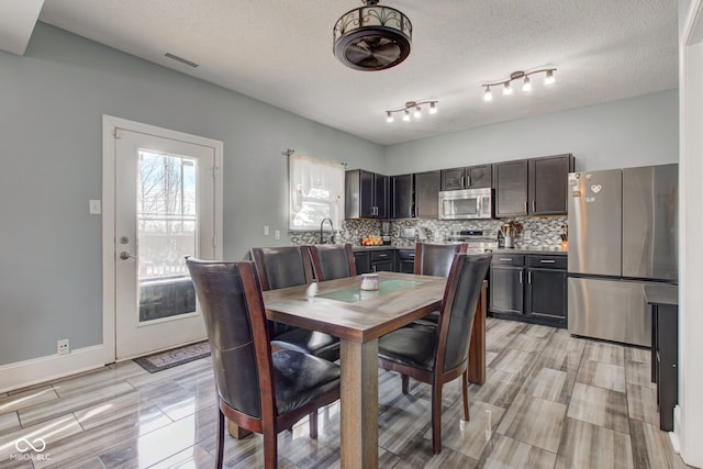 dining area featuring a textured ceiling and light hardwood / wood-style floors