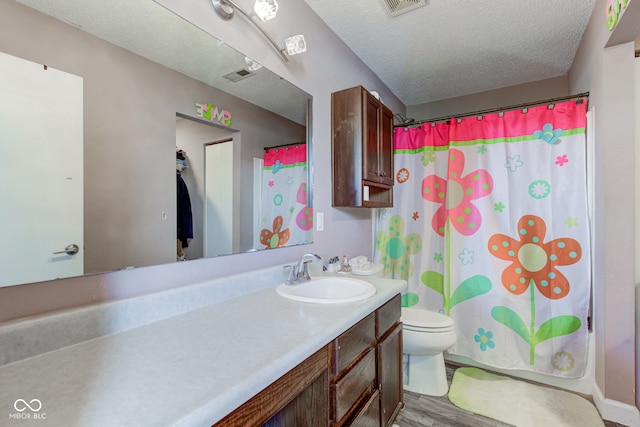 bathroom featuring wood-type flooring, vanity, toilet, a textured ceiling, and a shower with shower curtain