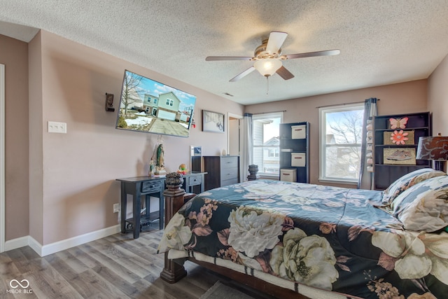 bedroom featuring a textured ceiling, wood-type flooring, and ceiling fan