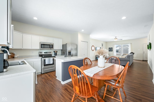 dining area featuring sink, dark wood-type flooring, and ceiling fan