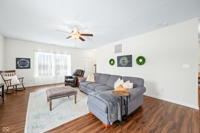 living room featuring dark wood-type flooring and ceiling fan