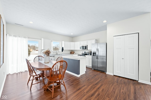 dining room with sink, a textured ceiling, and dark hardwood / wood-style flooring