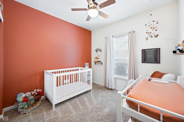 bedroom with a crib, carpet floors, and ceiling fan