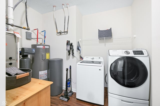 clothes washing area featuring independent washer and dryer, dark hardwood / wood-style floors, water heater, and a textured ceiling