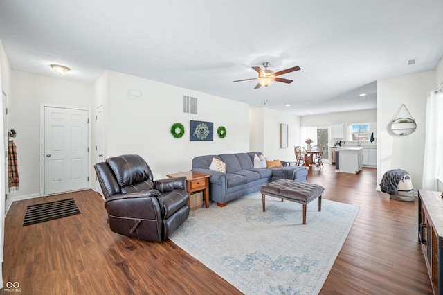 living room featuring ceiling fan and dark hardwood / wood-style flooring