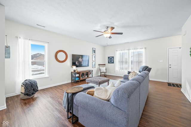 living room with dark hardwood / wood-style floors, a wealth of natural light, and ceiling fan