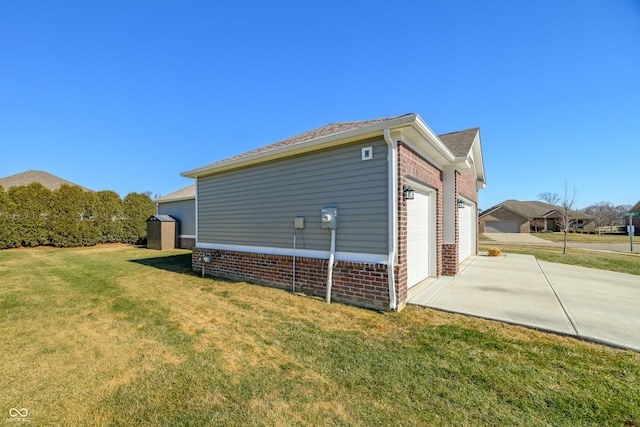 view of side of property featuring a garage, a storage unit, and a lawn