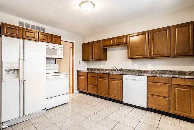 kitchen featuring white appliances, sink, and light tile patterned floors