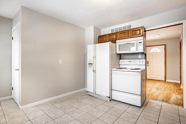 kitchen with white appliances and light tile patterned flooring