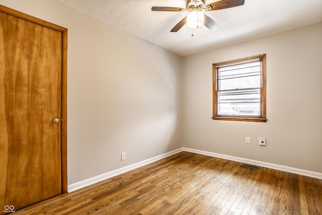 empty room with hardwood / wood-style floors and ceiling fan