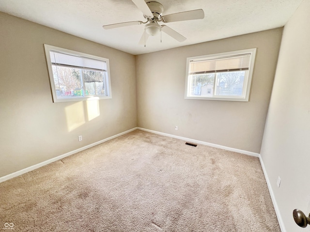 unfurnished room with ceiling fan, carpet, and a healthy amount of sunlight