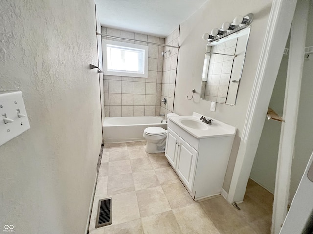 full bathroom featuring tiled shower / bath combo, vanity, and toilet