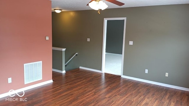 unfurnished room featuring ceiling fan, dark wood-type flooring, and a textured ceiling