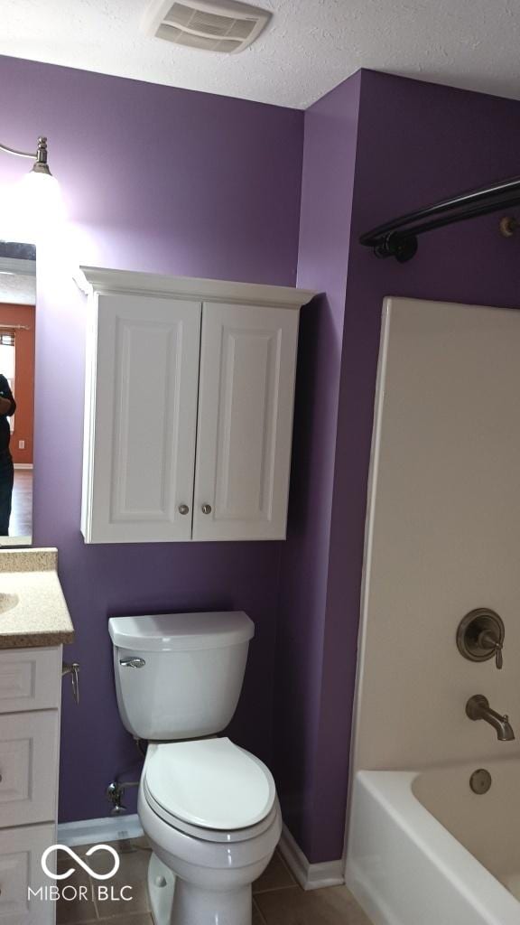 full bathroom featuring a textured ceiling, shower / bathing tub combination, tile patterned floors, vanity, and toilet