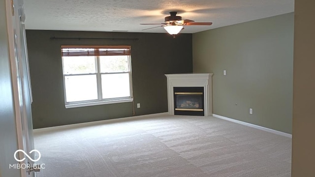 unfurnished living room featuring light carpet, a textured ceiling, and ceiling fan