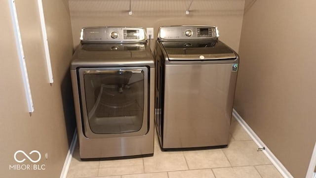 laundry room with light tile patterned floors and washing machine and clothes dryer