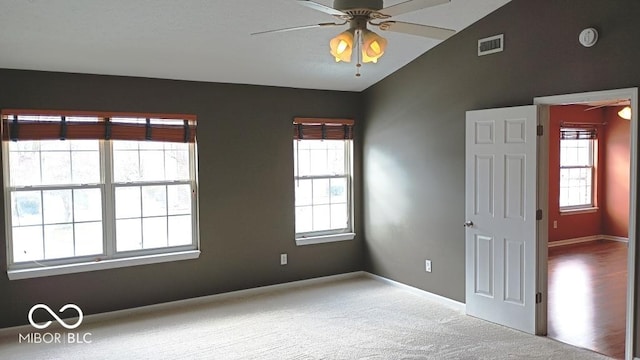 carpeted empty room with ceiling fan and vaulted ceiling