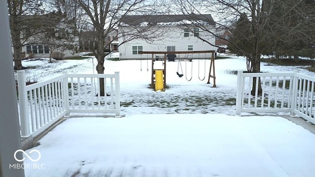 yard layered in snow with a playground