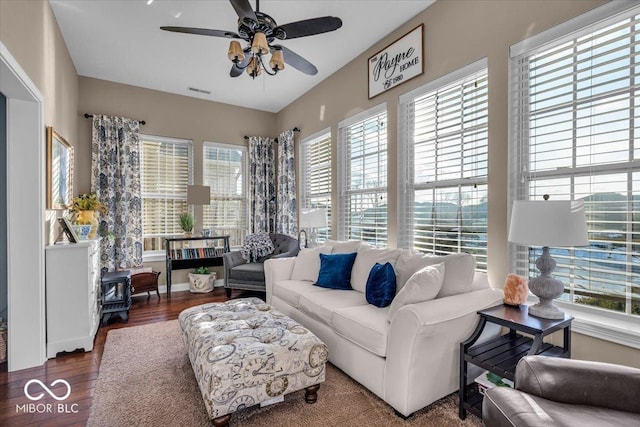 living room featuring a healthy amount of sunlight, ceiling fan, and dark hardwood / wood-style flooring