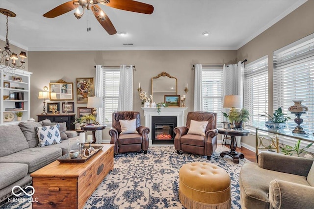 living room with light hardwood / wood-style floors, ornamental molding, and a healthy amount of sunlight