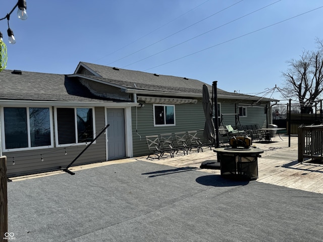 rear view of property with a fire pit and a patio