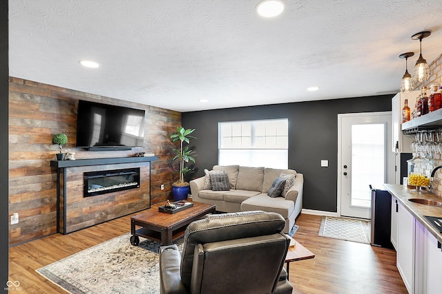 living room with a wealth of natural light, a fireplace, and light hardwood / wood-style floors