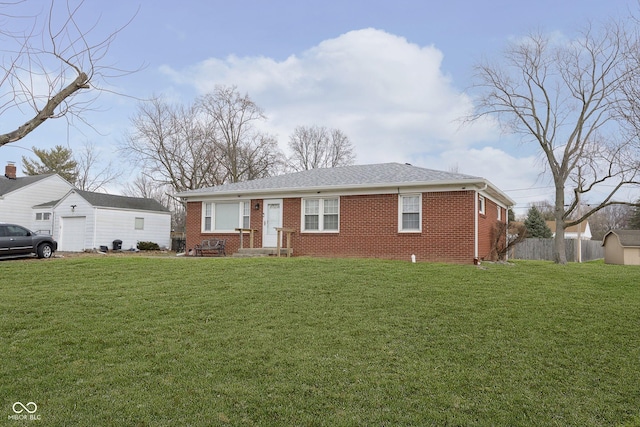 ranch-style home featuring a garage, an outbuilding, and a front lawn