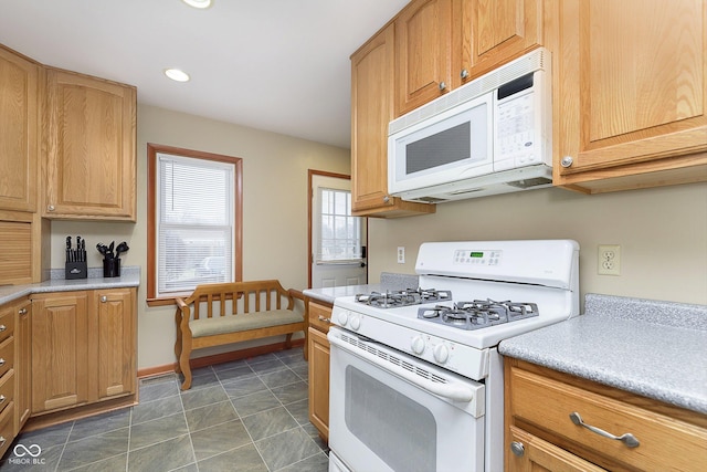 kitchen with white appliances and dark tile patterned floors