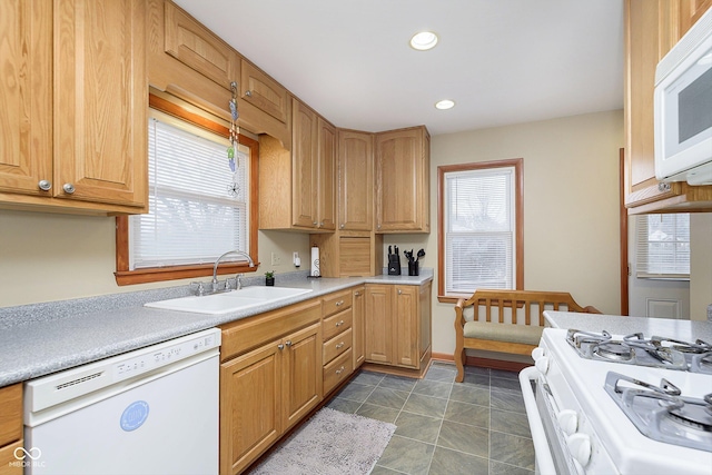 kitchen featuring white appliances, dark tile patterned floors, sink, and a wealth of natural light