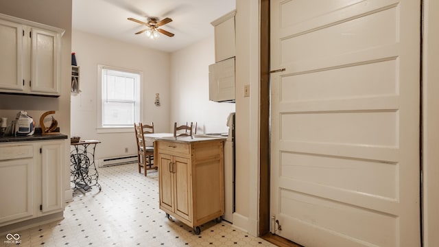 kitchen with cream cabinets, ceiling fan, and baseboard heating