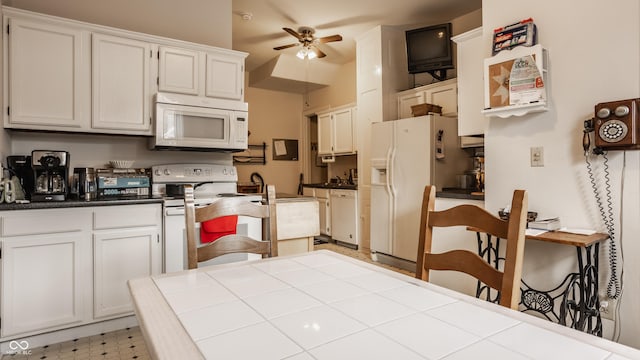 kitchen with white cabinets, white appliances, and tile countertops