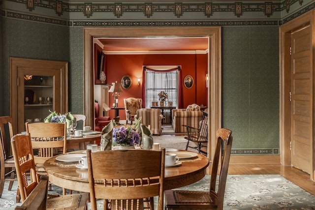 dining area with wood-type flooring and crown molding