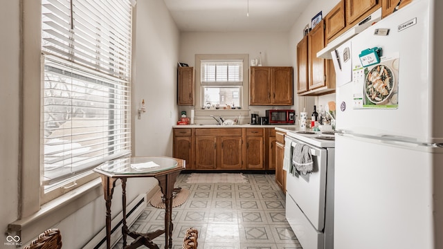 kitchen with sink, white appliances, and baseboard heating